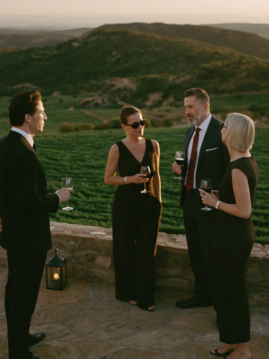 Directivos conversando con una copa de vino en la terraza de un cortijo al atardecer